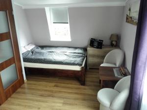 ビセウカにあるDom Borysのベッドと窓が備わる小さな客室です。
