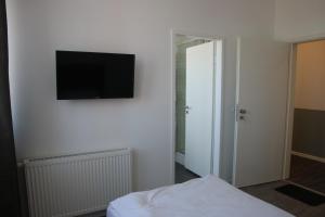 a room with a tv on a wall with a bed at Motel Schönefeld in Großziethen