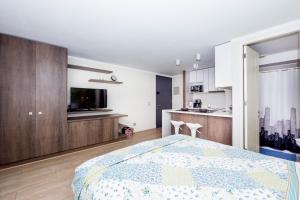 Un dormitorio con una cama grande y una cocina. en Arauco Studio Apartment, en Santiago
