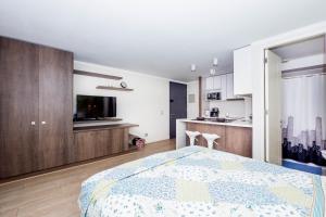 1 dormitorio con 1 cama grande y cocina en Arauco Studio Apartment, en Santiago
