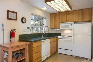 La cuisine est équipée d'un réfrigérateur blanc et d'un évier. dans l'établissement Jumping Deer, à Yosemite West