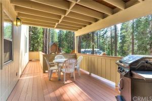 a screened in porch with a table and chairs and a grill at Jumping Deer in Yosemite West