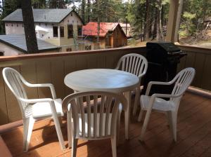 a white table and chairs on a porch with a grill at Jumping Deer in Yosemite West