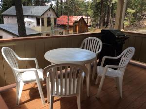 - une table et des chaises blanches sur une terrasse couverte avec barbecue dans l'établissement Jumping Deer, à Yosemite West
