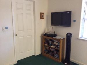 a room with a flat screen tv and a door at Jumping Deer in Yosemite West