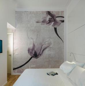 um quarto com uma cama com um quadro na parede em Maison Fleurie em Pescara