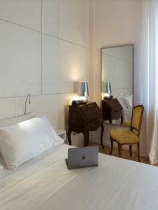 a bedroom with a bed with a laptop on it at Maison Fleurie in Pescara