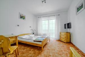 een slaapkamer met een bed, een bureau en een raam bij Villa Medica in Rabka