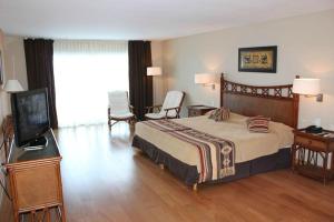 a bedroom with a bed and a flat screen tv at Howard Johnson Marinas & Resort in San Pedro