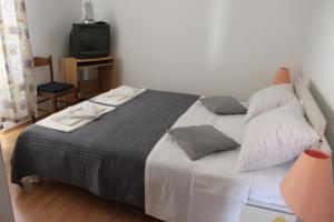 ein Schlafzimmer mit einem großen Bett und einem TV in der Unterkunft Apartments Suzi - parking in Bol