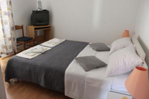 a bedroom with a large bed and a tv at Apartments Suzi - parking in Bol