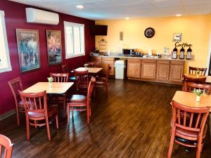 a restaurant with wooden tables and chairs and a kitchen at Hampton Inn (not a Hilton Affiliate) Camp Hill - Harrisburg SW in Harrisburg