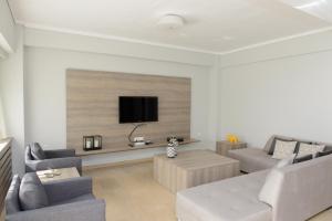 sala de estar con sofá y TV en la pared en Grey Suite Filoxenia, en Tesalónica