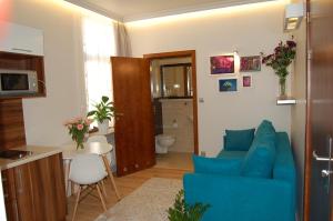 ein Wohnzimmer mit einem blauen Sofa und einer Küche in der Unterkunft Villa Star in Misdroy