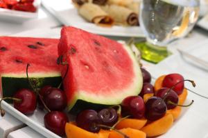 two slices of watermelon and fruit on a plate at Grand Alaçatı Butik Hotel in Alaçatı
