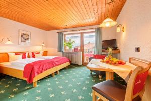 オーベルストドルフにあるFamilien- und Wellnesshotel "Landhaus Viktoria"のベッド1台、テーブル(フルーツ付)が備わる客室です。