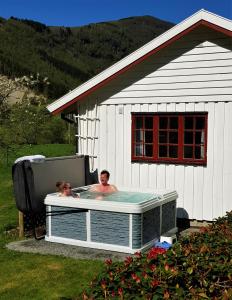 a man and a woman in a hot tub in a building at Dalhus - House in the Valley in Norddal