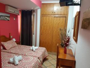 a bedroom with a bed and a table and a door at Pension los Verdiales in La Herradura