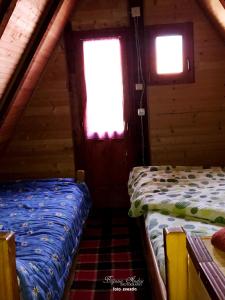 two beds in a room with two windows at Little heaven 2 in Mandići