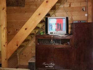 a television sitting on top of a wooden cabinet in a attic at Little heaven 2 in Mandići