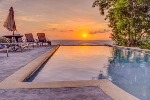 a swimming pool with a sunset over the ocean at SeaScape in West End