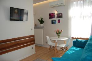 a living room with a blue couch and a table at Villa Star in Międzyzdroje