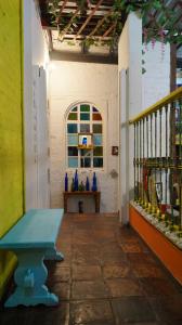 Habitación con banco azul y ventana en Lima Limon Candelaria Hostel, en Bogotá