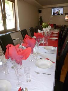 a long table with red napkins and glasses on it at Relax Penzion U Adama in Dolná Tižina