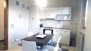 una cucina con tavolo nero ed elettrodomestici bianchi di Casa Vacanze Civico 19 a Matera