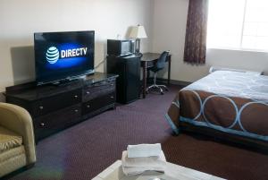 a hotel room with a bed and a flat screen tv at Cobblestone Inn & Suites – Platteville in Platteville