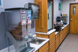 a kitchen with a sink and a counter with donuts at Cobblestone Inn & Suites – Platteville in Platteville