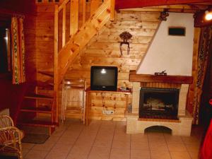 ein Wohnzimmer mit einem Kamin und einem TV in der Unterkunft Chalet Helalph in La Bresse