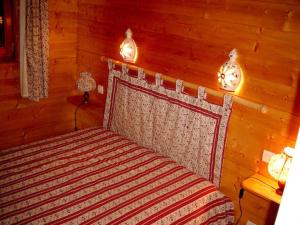 ein Schlafzimmer mit einem Bett in einem Holzzimmer in der Unterkunft Chalet Helalph in La Bresse