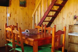a wooden table with chairs and a wooden staircase at Atayfú Cabañas in Colón