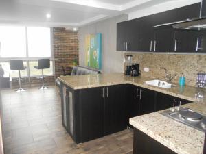 a kitchen with black cabinets and a counter top at Apartasuites AV in Medellín