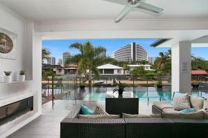 sala de estar con sofá y piscina en The Lotus, en Gold Coast