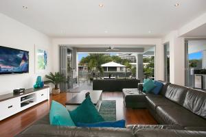 a living room with a brown leather couch and blue pillows at The Lotus in Gold Coast