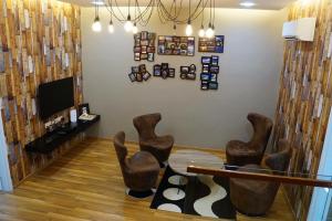 a living room with brown chairs and a tv at Shamrock Boutique Villa in Batu Ferringhi
