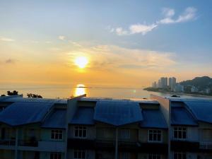 a building with a sunset in the background at Shamrock Boutique Villa - Stay for 12 person in Batu Ferringhi