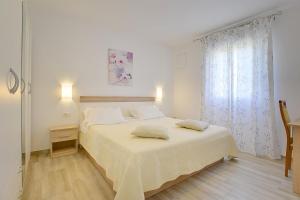 Un dormitorio blanco con una cama y una ventana. en Villa Fiorina, en Krnica 17 fotos más