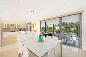 a white dining room with a white table and white chairs at Deluxe on Water in Gold Coast