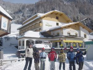 a group of people standing in the snow in front of a building at Hotel Berghof in Innerkrems