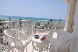 2 Stühle und ein Tisch auf einem Balkon mit Strandblick in der Unterkunft la Moretta in Marina di Ragusa