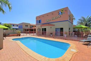 a large swimming pool in front of a building at Villa Mirasol Motor Inn in Bundaberg