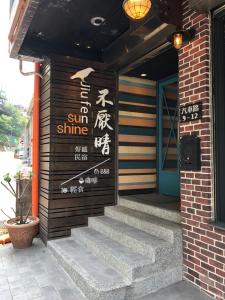 a sign on the side of a building with stairs at Sunshine B&B in Jiufen