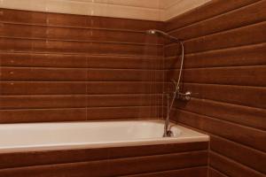 a bathroom with a bath tub with wooden walls at Villa Royce in Kandy