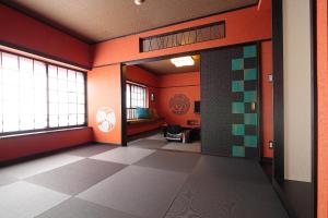 Cette chambre est dotée de murs orange et d'une porte ouverte. dans l'établissement Goyokan, à Izu