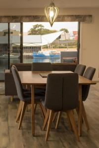 a dining room table and chairs with a view of a boat at Ulverstone Waterfront Apartments in Ulverstone