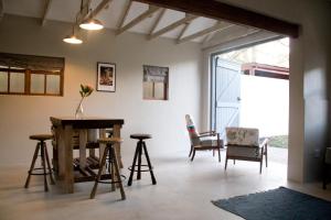 a living room with stools and a table and chairs at Avo&Oak Guesthouse in George