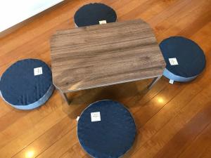 a wooden table with four chairs on a wooden floor at Nice Inn Hotel Ichikawa Tokyo Bay in Urayasu